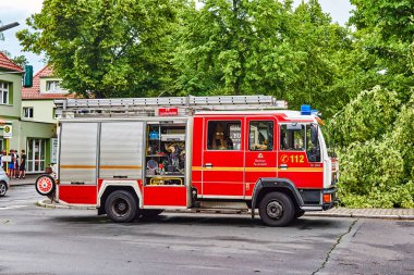Berlin, Almanya - 12 Haziran 2019: Şiddetli bir fırtınadan sonra Almanya 'nın Berlin kentinde ana caddede bulunan köklerinden sökülmüş bir ağaç. Kurtarma ekipleri kaza mahallinde çalışıyor..