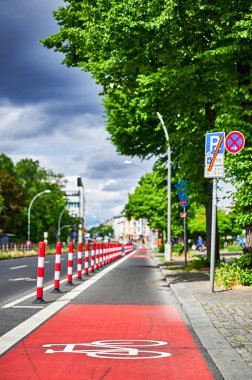 Berlin, Germany - May 29, 2022: Protected bike lane on a main street to improve road safety. The focus lies on the icon in the foreground.