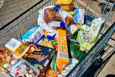 Berlin, Germany - July 25, 2022: View into a full shopping cart with various products for daily needs.