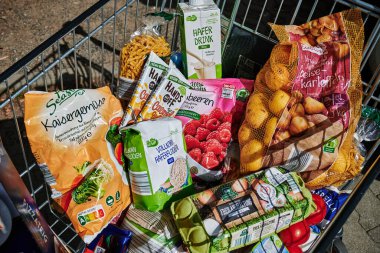 Berlin, Germany - September 1, 2022: View into a full shopping cart with various products for daily needs.