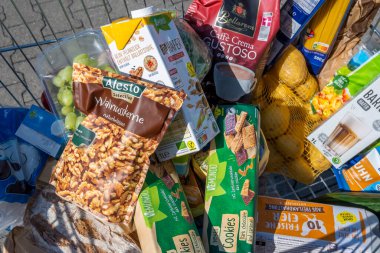 Berlin, Almanya - 9 Eylül 2022: Günlük ihtiyaçlar için çeşitli ürünlerle dolu bir alışveriş arabasına bakın.