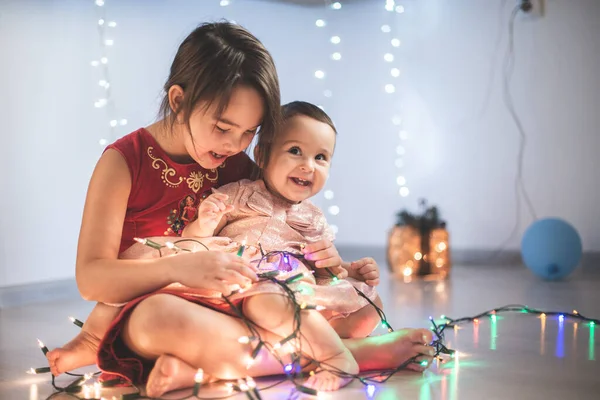 Młodsze Siostry Bawią Się Domu Światłami Bożonarodzeniowymi — Zdjęcie stockowe