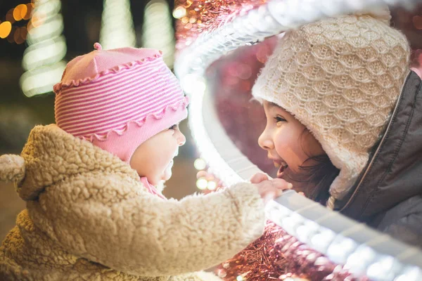 伝統的なクリスマスマーケットで楽しんでいる2人の妹 — ストック写真
