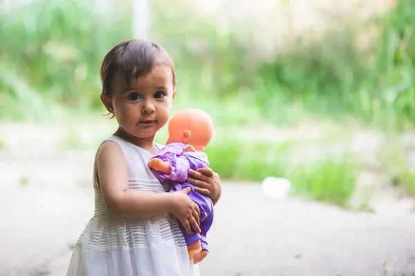 Cutte Holčička Bílými Šaty Držet Její Malé Dítě Panenku Náručí — Stock fotografie