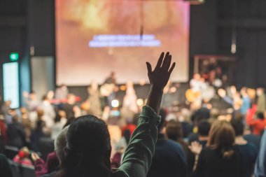 Kilise ayininde Tanrı 'ya şükreden insanların elleri havada.