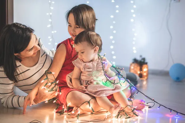 Matka Córkami Bawi Się Lampkami Świątecznymi — Zdjęcie stockowe