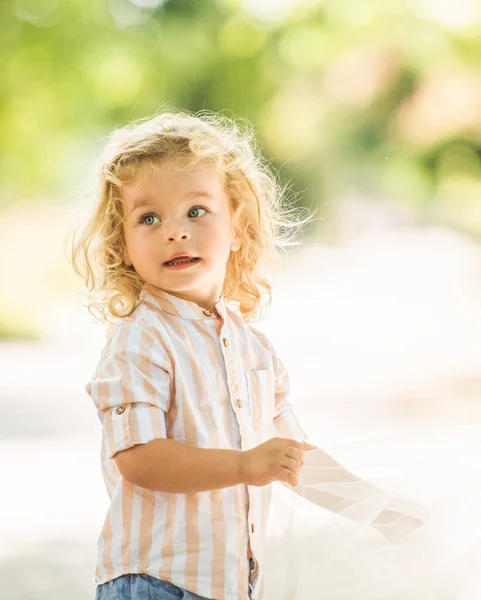 可愛いです男の子とともに巻きブロンド髪遊びで公園 — ストック写真