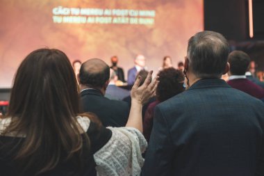 Kilise ayininde Tanrı 'ya şükreden insanların elleri havada.
