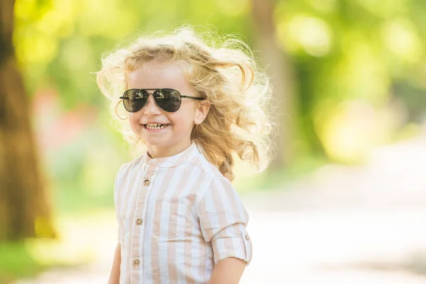 可愛いです男の子とともに巻きブロンド髪遊びで公園 — ストック写真