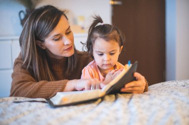 Anne ve küçük kızı sabahları yatağın kenarında dua ediyorlar.