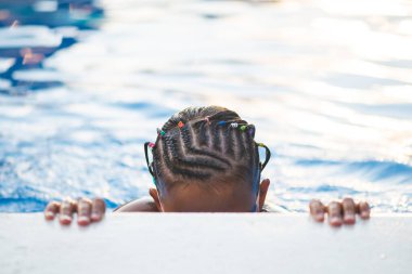 Havuzda küçük bir yüzücünün portresi.