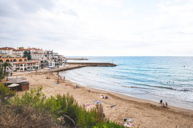 Güzel beyaz evler, Akdeniz ve batan güneşin altında açık mavi bir gökyüzü ve El Roc de Sant Gaieta, Katalonya 'da gün batımı