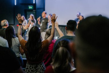 Kilise ayininde Tanrı 'ya şükreden insanların elleri havada.