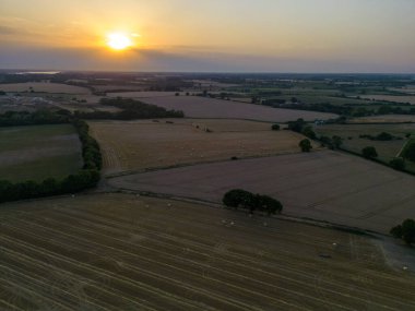 Freshly harvested wheat fields with neat rolls of straw scattered around. Under a tranquil Suffolk sunset.