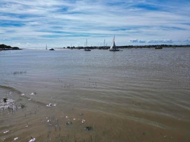 Nehirde ilginç bir gökyüzünün altında yüzen tekneler