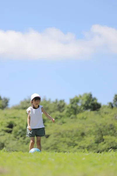 草の上でサッカーをする日本人女子学生 — ストック写真