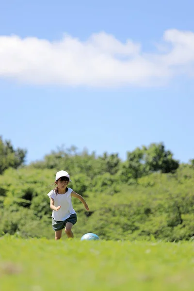 草の上でサッカーをする日本人女子学生 — ストック写真