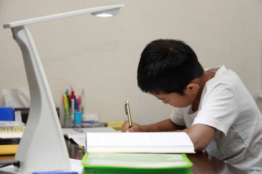 Japon çocuk yemek odasında öğrenim görüyor (ilkokulda beşinci sınıf)