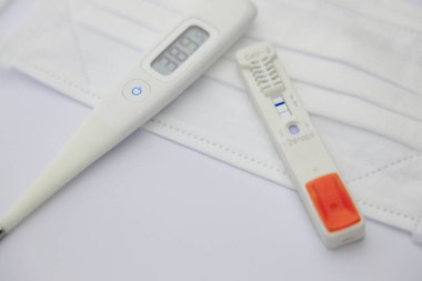 maske, termometre ve COVD-19 antijen testi pozitif