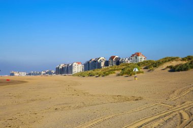 Sahil kasabasındaki boş kumsalları ve kumulları, mavi sonbahar gökyüzüne karşı izleyin - Knokke-Heist, Belçika