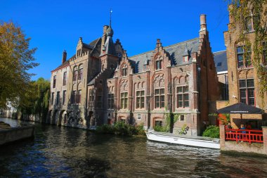 Brugge, Belçika - 9 Ekim. 2021: Ortaçağ 'daki açık mavi sonbahar gökyüzüne karşı çatısı olan eski su kanalına bakın.