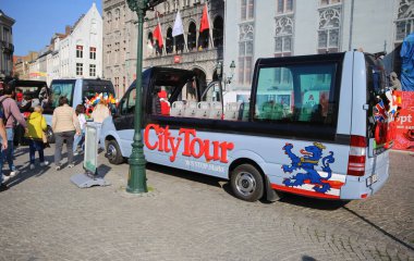 Brugge, Belçika - 9 Ekim. 2021: Güneşli bir günde Cabriolet şehir tur otobüsünün pazar meydanındaki görüntüsü (groote markt)