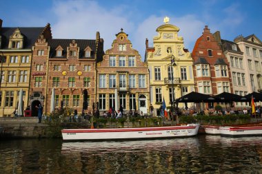 Gent (Grasbrug), Belçika - 9 Ekim. 2021: Dış kafe, turistik tekne turu rıhtımı ve ara binalara su kanalı manzarası