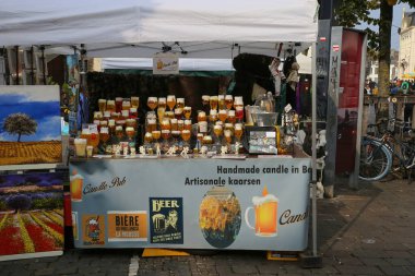 Gent, Belçika - 9 Ekim. 2021: Bit pazarında Belçika bira bardağı mumları satan tezgahın görüntüsü