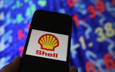 Viersen, Almanya - 6 Haziran. 2021: Kraliyet Hollanda kabuk yağı logosu ve borsa haritası içeren cep telefonu ekranının kapatılması