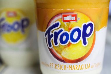 Viersen, Almanya - 9 Aralık. 2021: Plastik bardaktaki etiketin üzerinde Muller Froop meyveli yoğurt çölü logosu var
