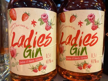 Viersen, Germany - December 9. 2021: Closeup of with logo lettering of bottles sweet ladies gin in shelf of german supermarket (focus on center of left bottle