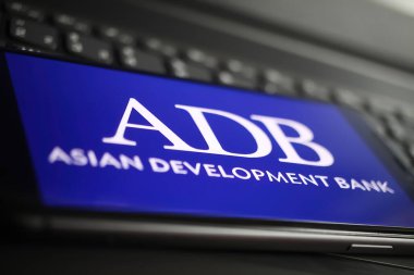 Viersen, Almanya - 9 Ocak. 2022: Cep telefonunun kapanması ve bilgisayar klavyesinde adb asisan geliştirme bankasının logosu