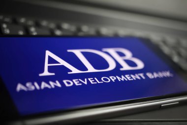 Viersen, Almanya - 9 Ocak. 2022: Cep telefonunun kapanması ve bilgisayar klavyesinde adb asisan geliştirme bankasının logosu