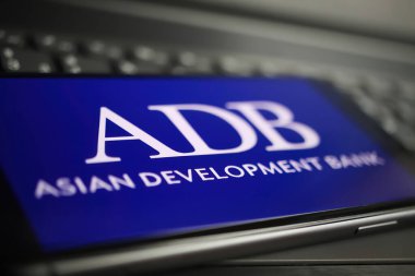 Viersen, Almanya - 9 Ocak. 2022: Cep telefonunun kapanması ve bilgisayar klavyesinde adb asisan geliştirme bankasının logosu