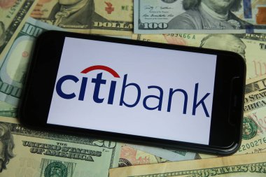 Viersen, Almanya - 9 Ocak. 2022: Citibank logosu olan cep telefonunun kapanışı, ABD dolar banknotları arka plan