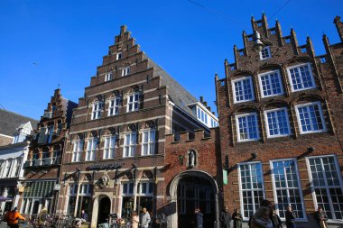 Hertogenbosch, Hollanda - 9 Şubat. 2022: Şehir merkezinde mavi kış gökyüzüne karşı tipik Hollandalı evleri ön cephede görmek