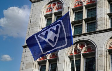 Maastricht, Hollanda - 9 Şubat. 2022: Mavi gökyüzüne karşı Hollandalı VVVV turist bilgilerinin logosuna sahip ziyaretçi merkezi pencereli eski ev cephesine bak