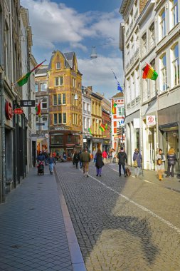 Maastricht, Hollanda - 13 Şubat. 2022: Güneşli Pazar günü alışveriş yapan insanlarla tarihi merkezde yaya caddesine bakın