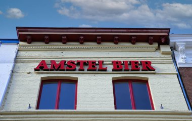 Roermond, Hollanda - 9 Şubat. 2022: Amstel bier logosu mavi gökyüzüne karşı logo harfleriyle restoran cephesine alçak açı