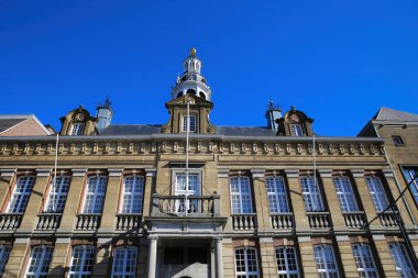 Roermond, Hollanda - 9 Şubat. 2022: Mavi gökyüzüne karşı çan kulesiyle tarihi belediye binasının cephesine bakın
