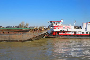 Nijmegen, Hollanda - 27 Şubat. 2022: HGK satıcı botu Herkül gemisi mavi gökyüzüne karşı kargo mavnası ile görünüyor 