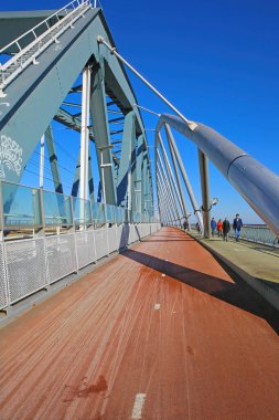 Nijmegen, Hollanda - 27 Şubat. 2022: Demiryolu köprüsünde mavi gökyüzüne karşı kırmızı bisiklet snelbinder yolunda görünüm