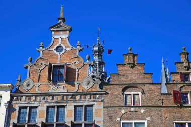 Mavi yaz gökyüzüne karşı kilise kulesiyle Orta Çağ 'a ait ev cephelerinin kapatılması - Nijmegen, Hollanda