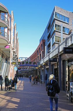 Nijmegen (Marikenstraat), Hollanda - 27 Şubat. 2022: Güneşli kış gününde yayalara bakan alışveriş caddesinde insanların görüntüsü