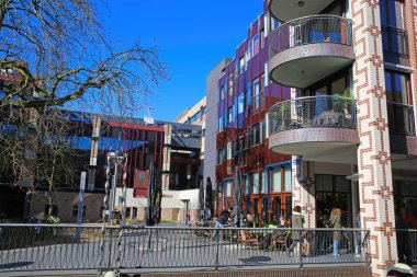 Nijmegen (Marikenstraat), Hollanda - 27 Şubat. 2022: Bulut gökyüzüne karşı dış kafesi olan modern kasaba binasının meydanına bakın