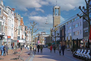 Nijmegen (Broerstraat), Hollanda - 27 Şubat. 2022: Kiliseyle yaya yolu manzarası, soğuk kış gününde alışveriş yapan insanlar