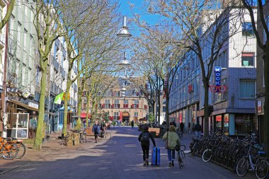 Nijmegen (Augustijnenstraat), Hollanda - 27 Şubat. 2022: Güneşli bir kış gününde insanlarla yaya alışveriş caddesinde tarihi ortaçağ pazar meydanına