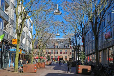 Nijmegen (Augustijnenstraat), Hollanda - 27 Şubat. 2022: Güneşli bir kış gününde insanlarla yaya alışveriş caddesinde tarihi ortaçağ pazar meydanına