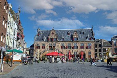 Nijmegen (grote markt), Hollanda - 27 Şubat. 2022: Güneşli bir günde kafeler, restoranlar ve eski ortaçağ binalarıyla dolu işlek pazar meydanını görmek