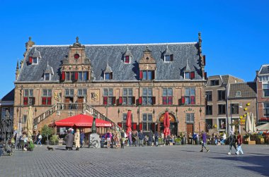 Nijmegen (grote markt), Hollanda - 27 Şubat. 2022: Güneşli bir günde kafeler, restoranlar ve eski ortaçağ binalarıyla dolu işlek pazar meydanını görmek